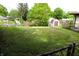 Spacious backyard with lush green grass, a storage shed, and chain link fence at 706 Bobs Ct, Beech Grove, IN 46107