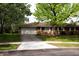 Brick home with a driveway and front lawn shaded by mature trees at 706 Bobs Ct, Beech Grove, IN 46107