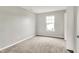 A gray-toned carpeted bedroom with an abundance of natural light from a window at 714 Thornburg Pkwy, Brownsburg, IN 46112
