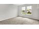 The light-filled bedroom has a carpeted floor, celestial wall decorations, and double windows with a neighborhood view at 714 Thornburg Pkwy, Brownsburg, IN 46112