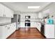Well-lit kitchen featuring granite counters, stainless appliances, white cabinets, and wood flooring at 714 Thornburg Pkwy, Brownsburg, IN 46112