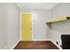 Laundry room with yellow door and shelf, and wood-look floor at 714 Thornburg Pkwy, Brownsburg, IN 46112