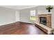 Living room featuring hardwood floors, stone fireplace, and a large window at 714 Thornburg Pkwy, Brownsburg, IN 46112