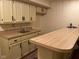 Wet bar area in basement featuring cabinets, sink, countertop, and bar seating at 7440 Sylvan Ridge Rd, Indianapolis, IN 46240
