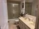 Well-lit bathroom with a double vanity, tile flooring, and a shower/tub combo with sliding glass door at 7440 Sylvan Ridge Rd, Indianapolis, IN 46240