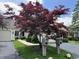 Beautifully landscaped front yard with a vibrant red maple tree and well-maintained lawn at 7440 Sylvan Ridge Rd, Indianapolis, IN 46240