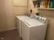Laundry room featuring a modern washer and dryer set, and overhead shelving at 7440 Sylvan Ridge Rd, Indianapolis, IN 46240
