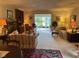 Inviting living room featuring a fireplace, comfortable seating, and access to sunroom with lake views at 7440 Sylvan Ridge Rd, Indianapolis, IN 46240