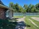 Outdoor tennis court surrounded by greenery and a paved walkway, as seen from the building at 7440 Sylvan Ridge Rd, Indianapolis, IN 46240