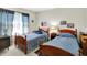This bedroom boasts two twin beds with matching wooden frames and blue bedspreads at 7587 Winding Way, Fishers, IN 46038