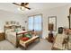 Comfortable bedroom with a wooden bed frame and a bench full of cushions and a ceiling fan at 7587 Winding Way, Fishers, IN 46038