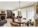 Bright dining area with a round wooden table, seating for four, and view to the fireplace and built-in shelving at 7587 Winding Way, Fishers, IN 46038
