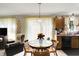 Cozy dining area open to the kitchen features a round table with seating and ample natural light from the large window at 7587 Winding Way, Fishers, IN 46038