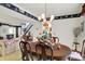 A dining area with wood table, decorative wallpaper border, chandelier, open to living room and staircase at 7587 Winding Way, Fishers, IN 46038