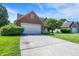 Brick accent home with attached garage, long driveway, mature tree, and manicured lawn at 7587 Winding Way, Fishers, IN 46038