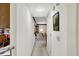 Hallway with white walls and neutral carpet, leading to the kitchen and living spaces, enhanced by framed artwork at 7587 Winding Way, Fishers, IN 46038