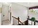 Bright hallway featuring a window, staircase, and neutral decor for a welcoming transition between spaces at 7587 Winding Way, Fishers, IN 46038