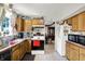 Functional kitchen with wood cabinets, black and white appliances, and a view of the adjacent dining area at 7587 Winding Way, Fishers, IN 46038
