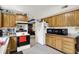 A cozy kitchen with wood cabinetry, appliances, and view of adjacent dining area, creating a functional space at 7587 Winding Way, Fishers, IN 46038