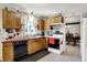 A practical kitchen boasts wood cabinets, ample counter space, and view of adjacent dining area, adding convenience at 7587 Winding Way, Fishers, IN 46038