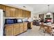 An open kitchen features wood cabinets, workspace, with a view to living room and dining area at 7587 Winding Way, Fishers, IN 46038