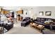 Spacious living room featuring plush leather furniture, a coffee table with car models, and an open view to the kitchen at 7587 Winding Way, Fishers, IN 46038