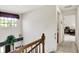 Well-lit upstairs hallway with a window and view, leading to additional rooms with a wooden railing at 7587 Winding Way, Fishers, IN 46038