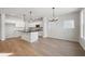 Open-concept kitchen with white cabinets, stainless appliances, granite countertops and hardwood floors at 786 James William Ln, Westfield, IN 46074