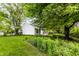 Lush backyard with mature trees, garden beds, and a cozy screened porch, offering a private outdoor retreat at 9118 Hardwood Ct, Indianapolis, IN 46250
