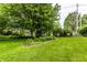 Expansive backyard showcasing a well-maintained lawn, mature trees, and garden bed for a serene outdoor experience at 9118 Hardwood Ct, Indianapolis, IN 46250