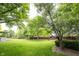 Large, grassy backyard featuring mature trees, landscaping and plenty of space for outdoor activities and relaxation at 9127 Pointe Ct, Fishers, IN 46037