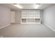Spacious basement featuring gray carpet, paint, and a large white built-in bookshelf for storage and display at 9127 Pointe Ct, Fishers, IN 46037