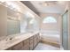 Well-lit bathroom featuring double vanity, garden tub, separate shower, and large window for natural light at 9127 Pointe Ct, Fishers, IN 46037