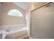 Bathroom showcasing a tiled garden tub and glass shower with a window that allows natural light at 9127 Pointe Ct, Fishers, IN 46037