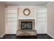 Living room featuring a brick fireplace, custom built-ins, and a decorative mirror at 9127 Pointe Ct, Fishers, IN 46037