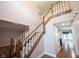 Elegant foyer with a staircase featuring wood railings, carpeted steps, and a view of the kitchen at 9127 Pointe Ct, Fishers, IN 46037