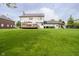 Sprawling backyard with lush green grass, a deck, and playset, perfect for outdoor activities at 10144 Water Crest Dr, Fishers, IN 46038