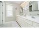 Well-lit bathroom with double sinks, white cabinetry, framed mirrors, and vanity lighting at 10144 Water Crest Dr, Fishers, IN 46038