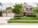 Charming brick two-story home with a well-manicured lawn, mature trees, and black shutters at 10144 Water Crest Dr, Fishers, IN 46038