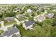 Aerial shot showcasing a well-maintained neighborhood with lush green spaces, a pond, and diverse homes at 10144 Water Crest Dr, Fishers, IN 46038