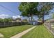 Large grassy backyard featuring a walkway, privacy fence, and mature trees provides great outdoor space at 1132 Evison St, Indianapolis, IN 46203