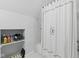 Bathroom featuring an enclosed bathtub shower, a patterned shower curtain, and built-in shelves with storage at 1132 Evison St, Indianapolis, IN 46203