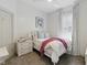 Cozy bedroom with white walls, a comfortable bed, bedside table, and a sunlit window with curtains at 1132 Evison St, Indianapolis, IN 46203