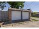 A detached two-car garage with brick facade and white doors provides ample parking and storage at 1132 Evison St, Indianapolis, IN 46203
