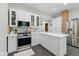 Stylish kitchen with modern appliances, white cabinets, a breakfast bar, and stainless steel refrigerator at 1132 Evison St, Indianapolis, IN 46203
