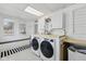 Spacious laundry room with dual front-loading washer and dryer, wooden counters, and ample cabinet space at 1132 Evison St, Indianapolis, IN 46203