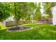 Lush backyard featuring a wooden deck with an umbrella table, surrounded by greenery and a wooden privacy fence at 11419 Niagara Dr, Fishers, IN 46037