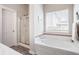 White bathroom with bath tub and shower with clear glass doors at 11419 Niagara Dr, Fishers, IN 46037
