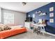 Modern bedroom featuring a navy accent wall with decorations and a study desk at 11419 Niagara Dr, Fishers, IN 46037