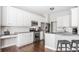 Well-lit kitchen boasts white cabinets, stainless steel appliances, granite countertops, subway tile backsplash, and wood floors at 11419 Niagara Dr, Fishers, IN 46037